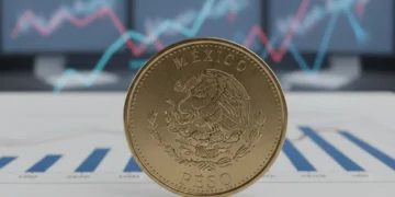 Moneda de peso mexicano sobre documentos financieros, simbolizando los cambios en las tasas de interés del Banco de México para 2026 y su impacto en créditos.
